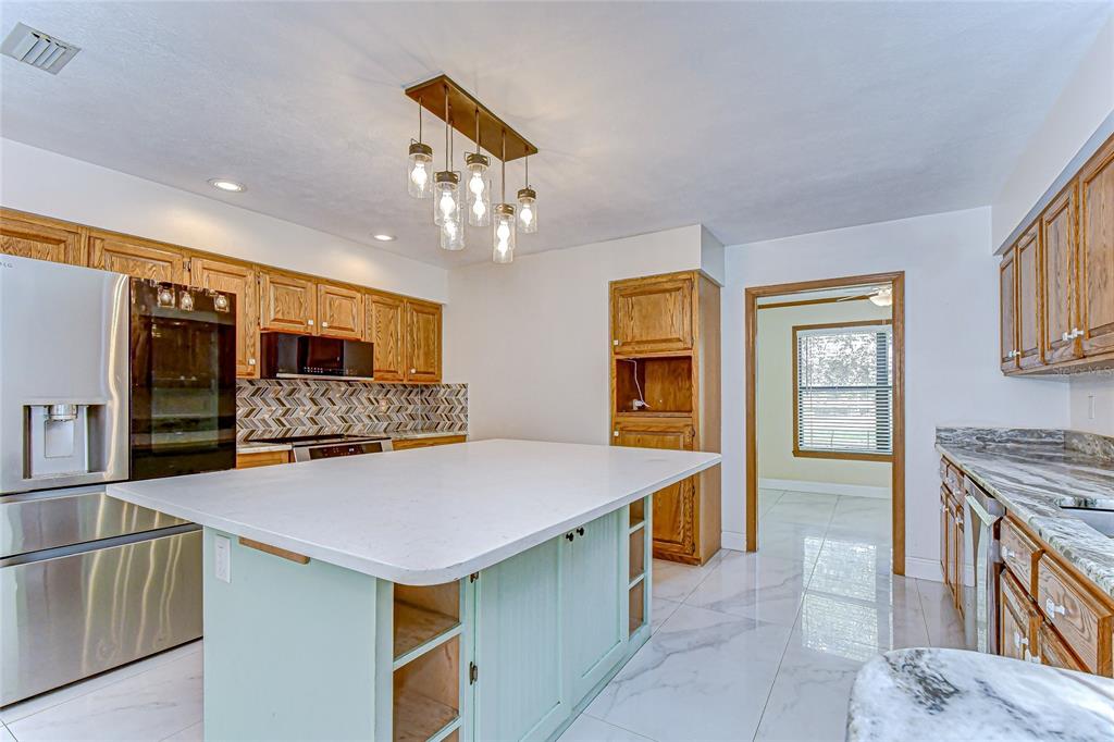 16349 Spring Valley Road Dade City, FL 33523 - Photo 21 of 40 a kitchen with a stove and a refrigerator