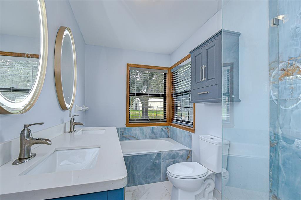16349 Spring Valley Road Dade City, FL 33523 - Photo 26 of 40 a bathroom with a sink a toilet and a mirror