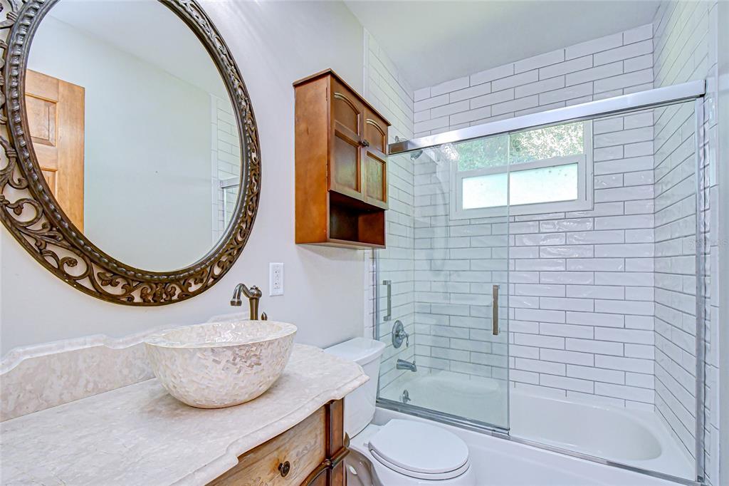 16349 Spring Valley Road Dade City, FL 33523 - Photo 31 of 40 a bathroom with a toilet a sink and mirror