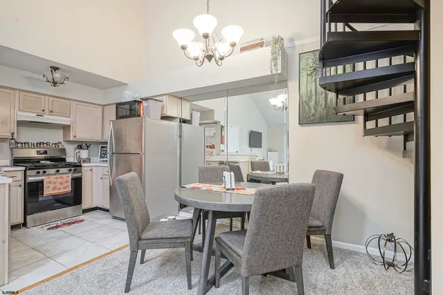 a view of kitchen with refrigerator stove dining table and chairs