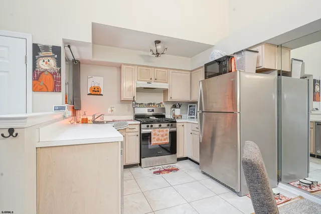 a kitchen with stainless steel appliances granite countertop a refrigerator sink and stove