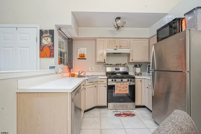 a kitchen with stainless steel appliances granite countertop a sink a stove a refrigerator and a refrigerator