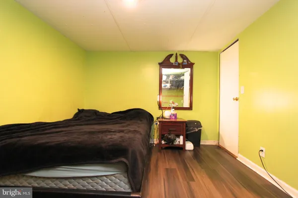 a living room with a bed furniture and a wooden floor