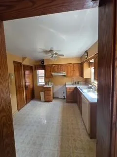 a large kitchen with stainless steel appliances granite countertop a sink and cabinets