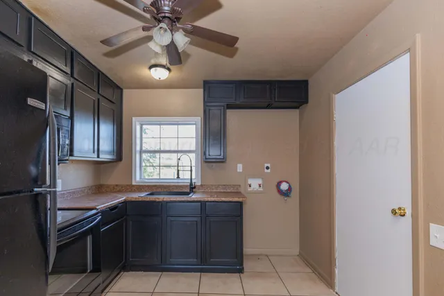 a kitchen with granite countertop a refrigerator and a sink