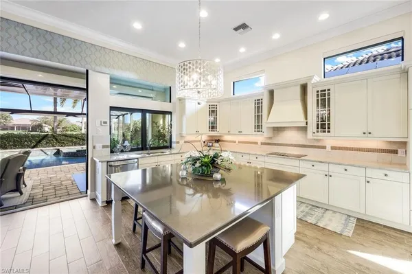 a kitchen with granite countertop a table chairs sink and wooden floor