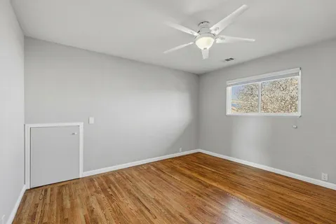 a view of an empty room with wooden floor