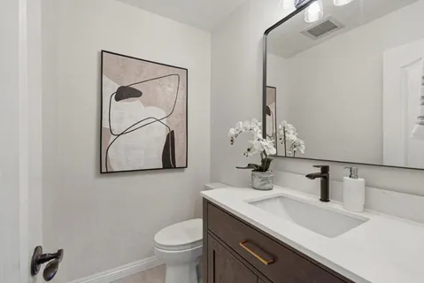 a bathroom with a sink vanity and toilet