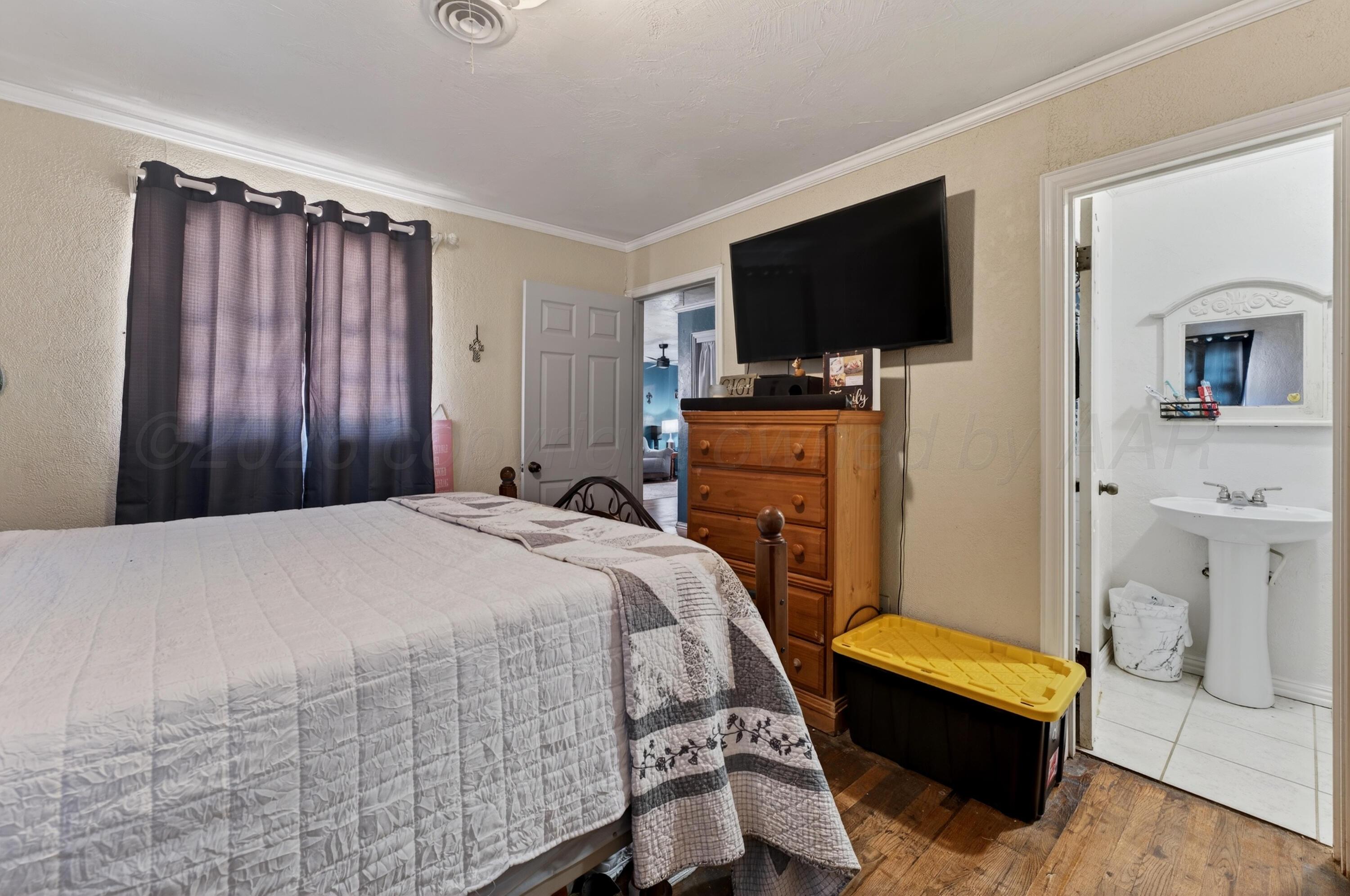 2519 9th Avenue Canyon, TX 79015 - Photo 11 of 24 a bedroom with a bed and a flat screen tv