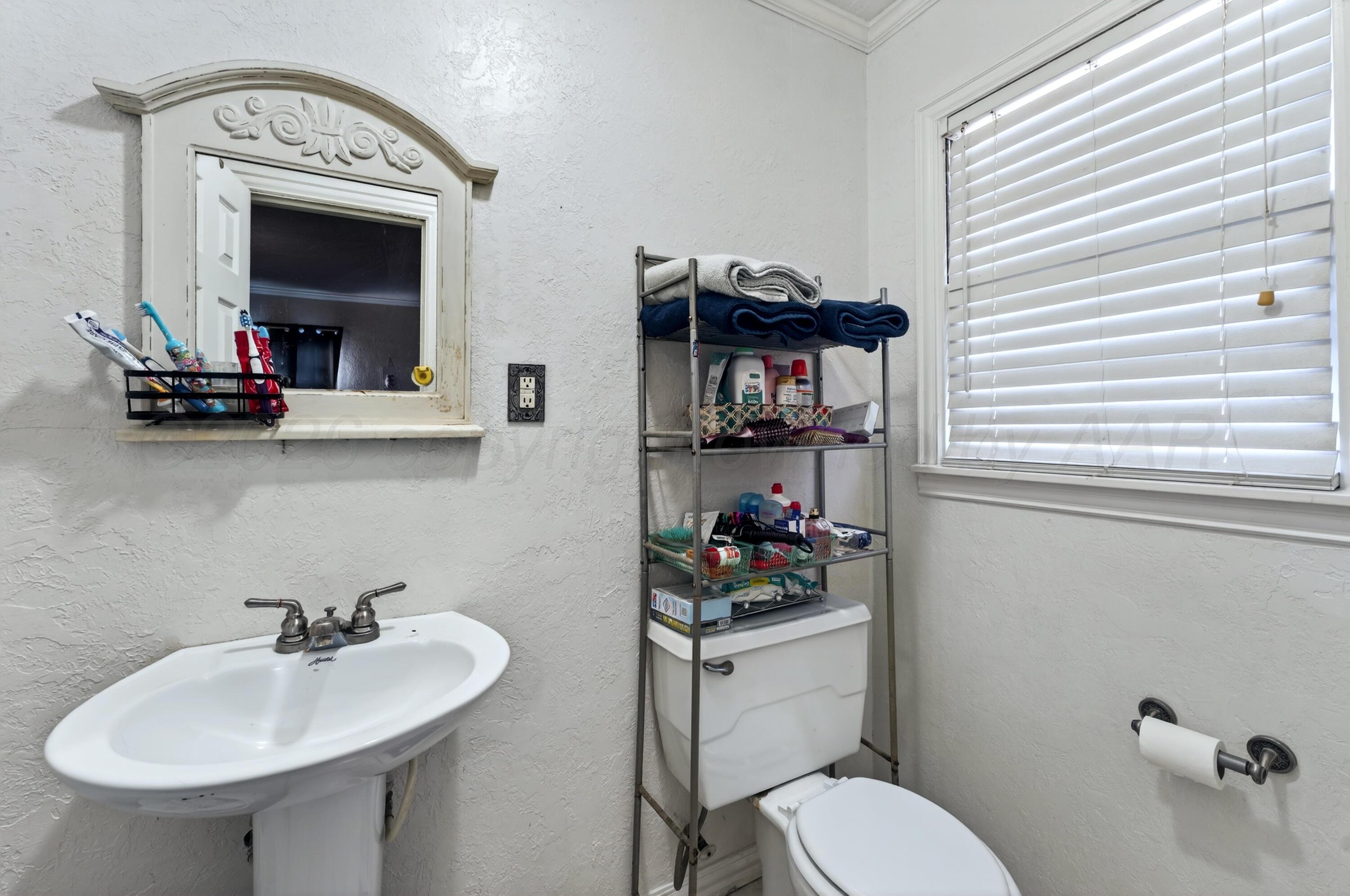 2519 9th Avenue Canyon, TX 79015 - Photo 12 of 24 a bathroom with a toilet sink and mirror