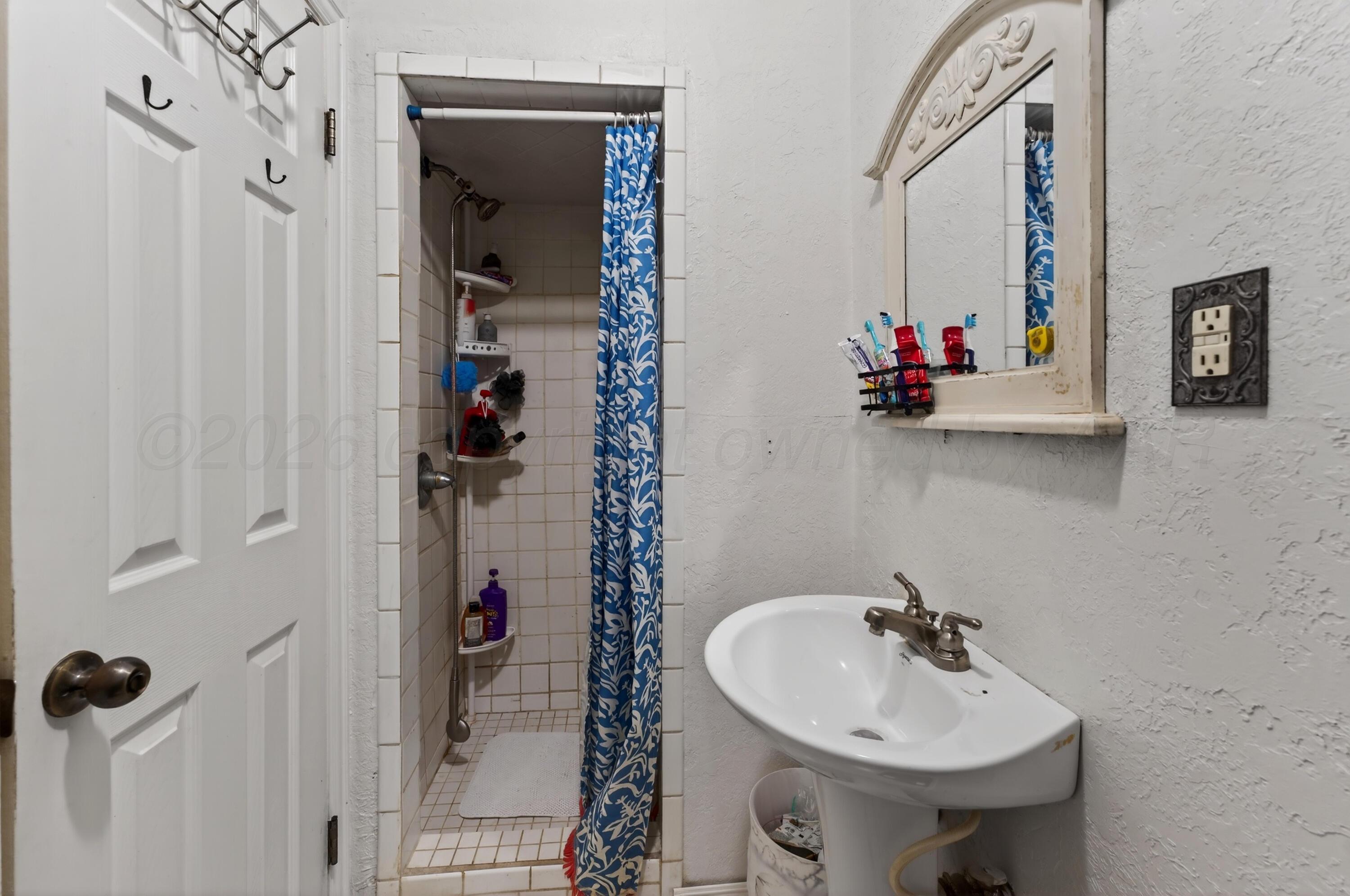 2519 9th Avenue Canyon, TX 79015 - Photo 13 of 24 a bathroom with a sink and mirror