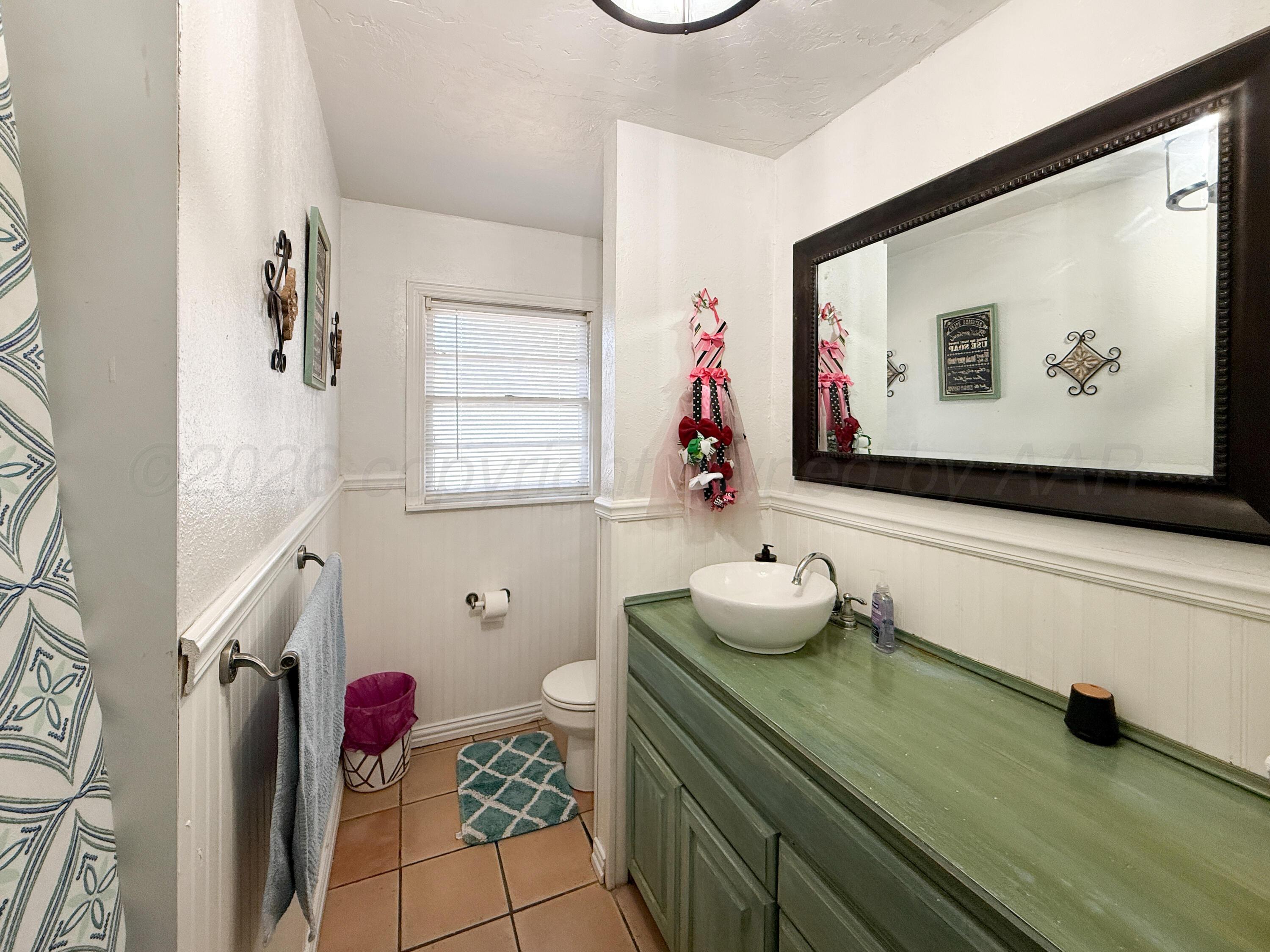 2519 9th Avenue Canyon, TX 79015 - Photo 14 of 24 a bathroom with a sink and a mirror