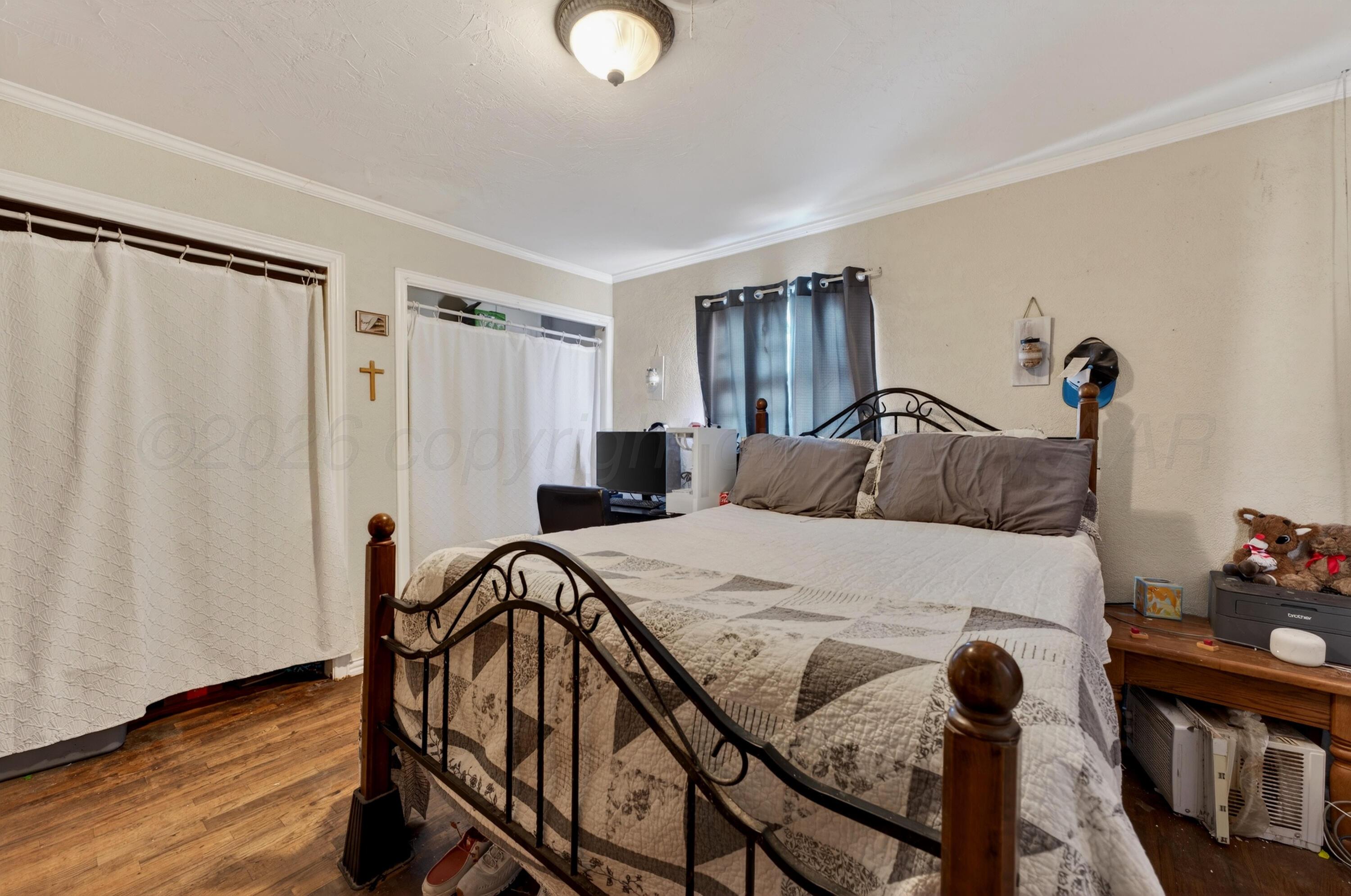 2519 9th Avenue Canyon, TX 79015 - Photo 20 of 24 a bedroom with a bed and wooden floor