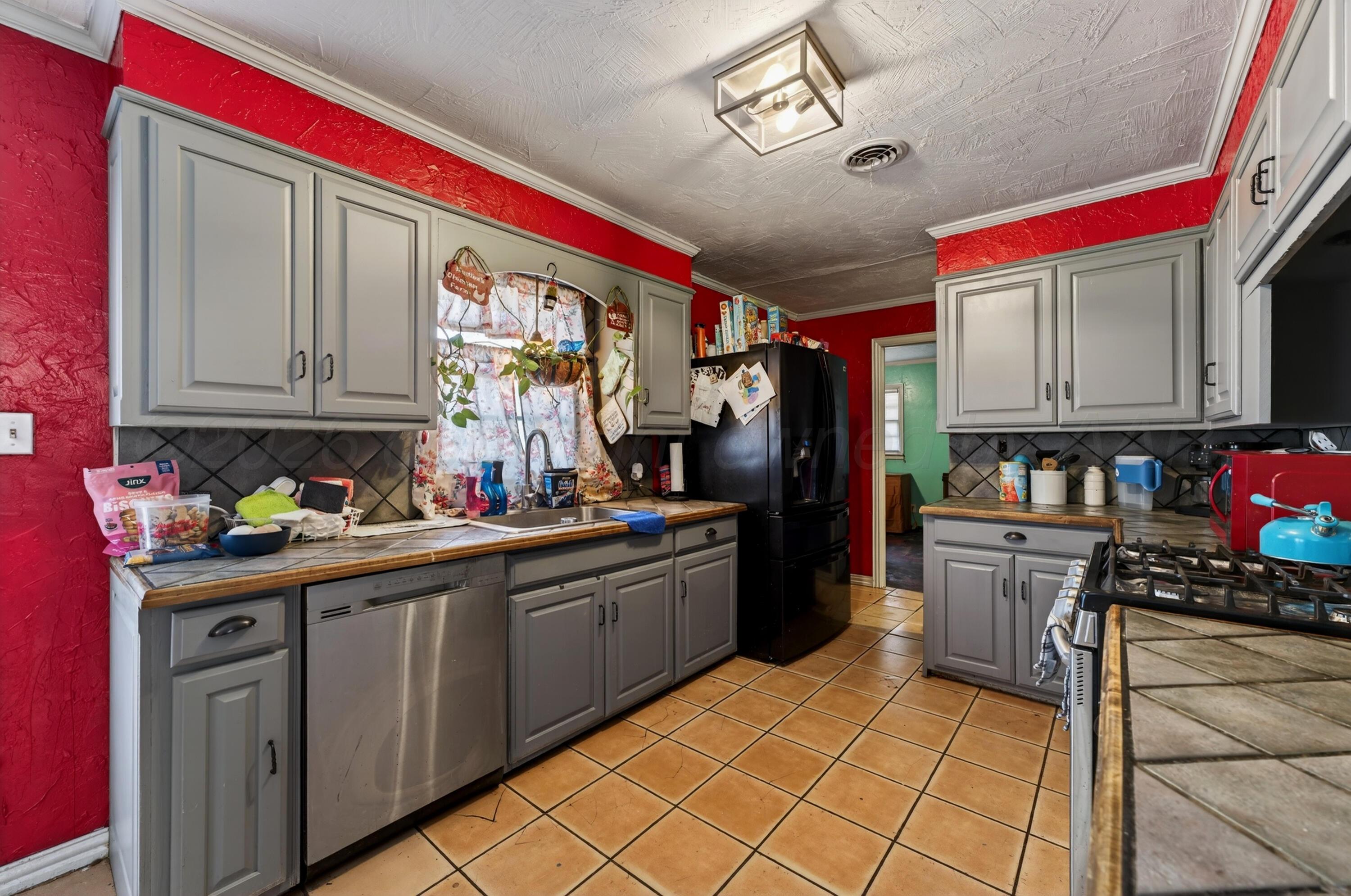 2519 9th Avenue Canyon, TX 79015 - Photo 6 of 24 a kitchen with stainless steel appliances granite countertop a stove sink cabinets and window