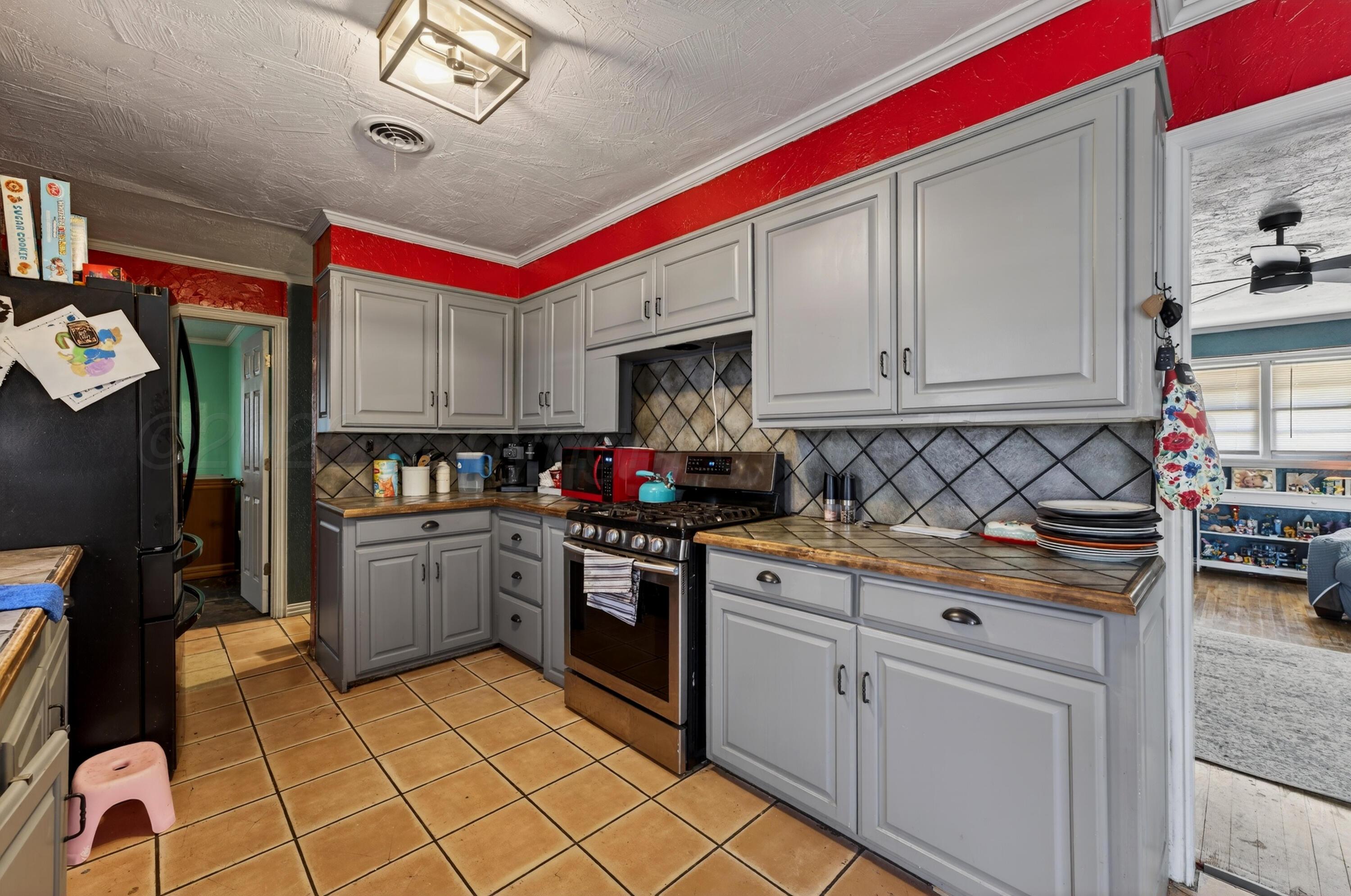 2519 9th Avenue Canyon, TX 79015 - Photo 7 of 24 a kitchen with stainless steel appliances granite countertop a stove sink and cabinets