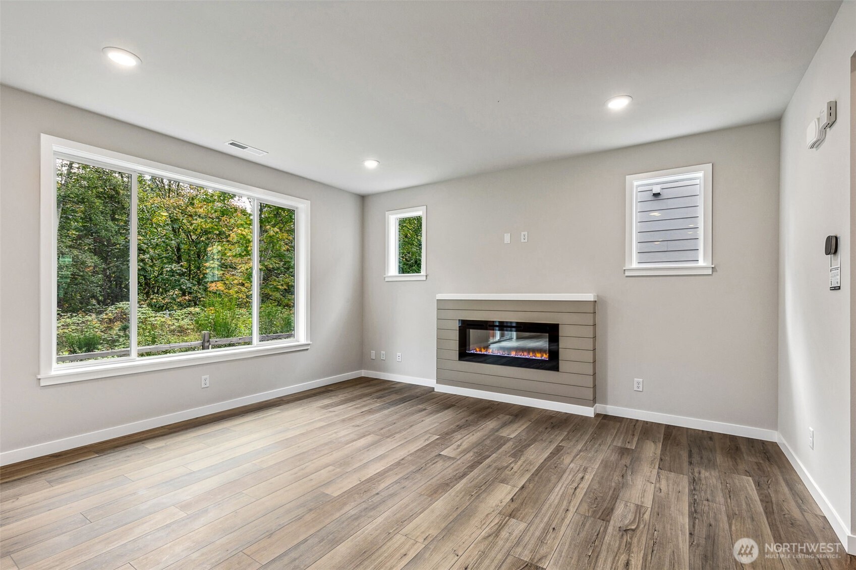 13406 323rd Drive Southeast Sultan, WA 98294 - Photo 14 of 29 an empty room with windows a fireplace and wooden floor