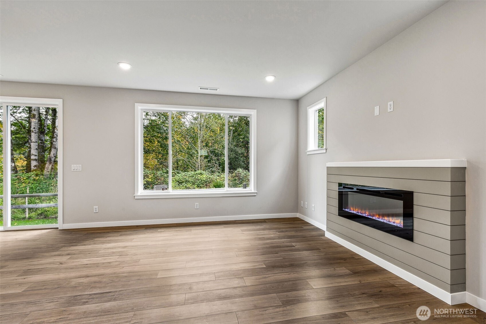 13406 323rd Drive Southeast Sultan, WA 98294 - Photo 4 of 29 an empty room with wooden floor fireplace and windows