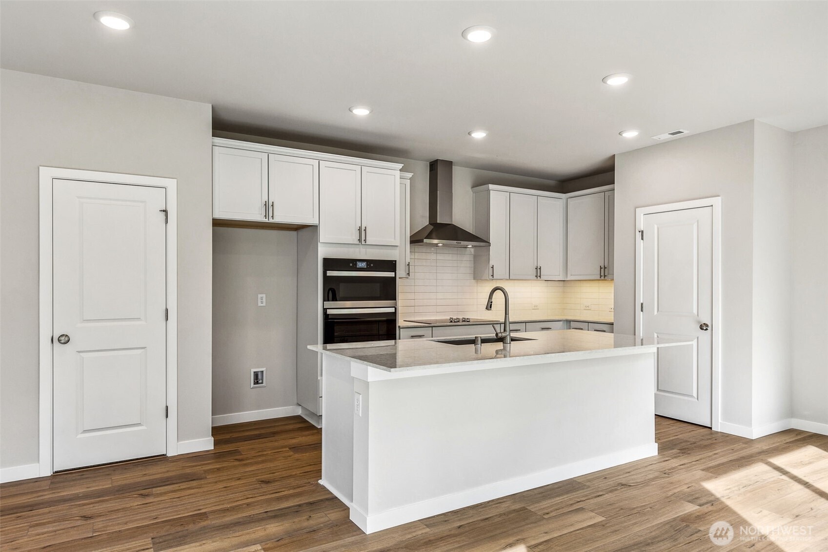 13406 323rd Drive Southeast Sultan, WA 98294 - Photo 7 of 29 a kitchen with stainless steel appliances granite countertop a refrigerator a sink a stove and white cabinets with wooden floor