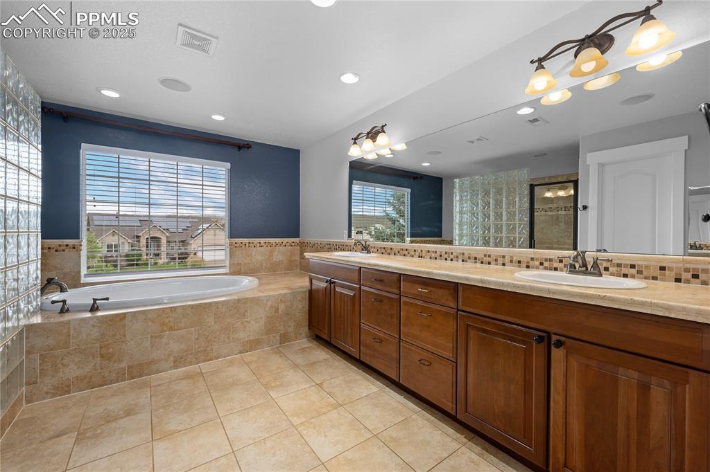 1069 Glengary Place Colorado Springs, CO 80921 - Photo 20 of 36 Full bathroom featuring a garden tub, light tile patterned floors, double vanity, recessed lighting, and a shower stall