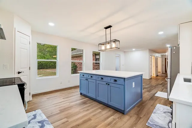a kitchen with stainless steel appliances granite countertop wooden floors and granite counter tops