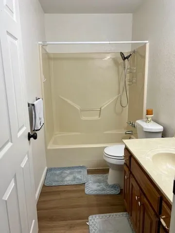 a bathroom with a granite countertop sink toilet and shower