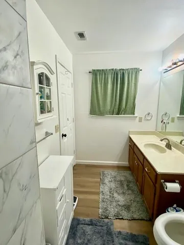 a bathroom with a granite countertop sink mirror vanity and bathtub