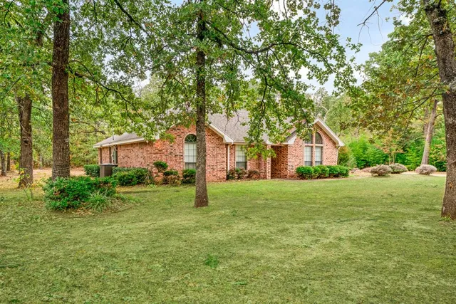 a front view of a house with a yard and trees