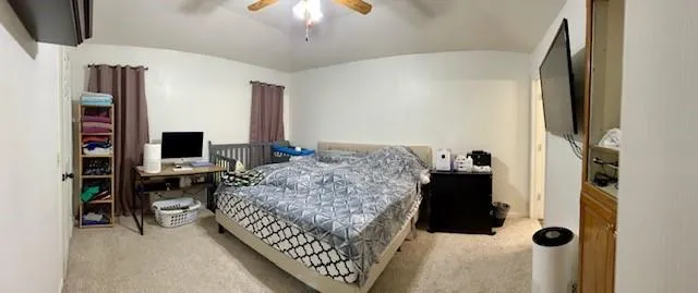 a living room with a bed furniture and a flat screen tv