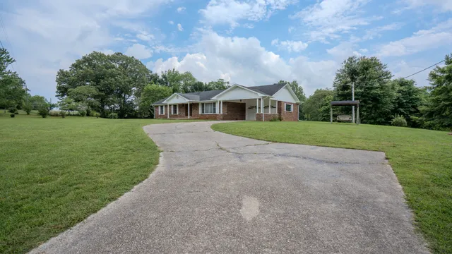 a view of a house with a yard and sitting area