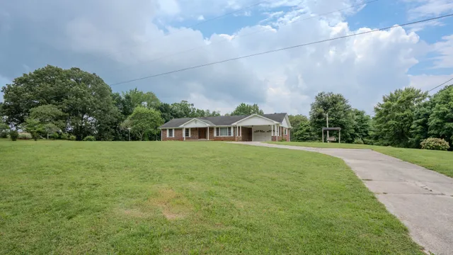 a view of a big yard with a house in the background