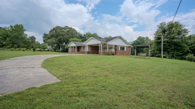 a view of a house with a big yard and potted plants