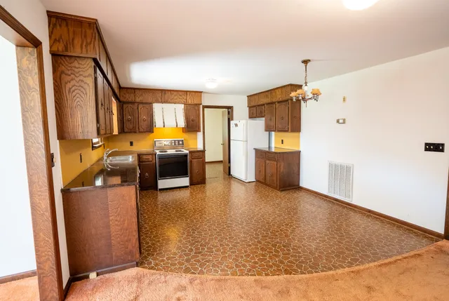 a view of a kitchen with a sink a refrigerator and a stove
