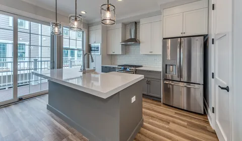 a kitchen with kitchen island a counter top space wooden floor and stainless steel appliances