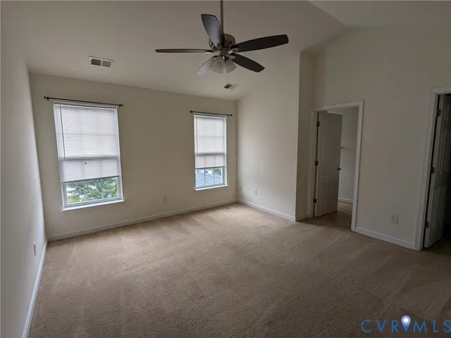 an empty room with windows and ceiling fan