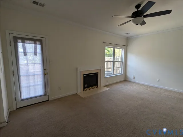 an empty room with windows and fireplace