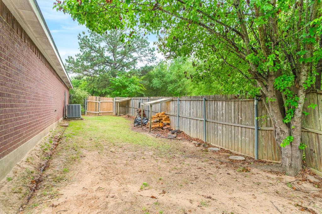 560 Washington Street Van, TX 75790 - Photo 29 of 29 a view of a backyard with large trees and wooden fence