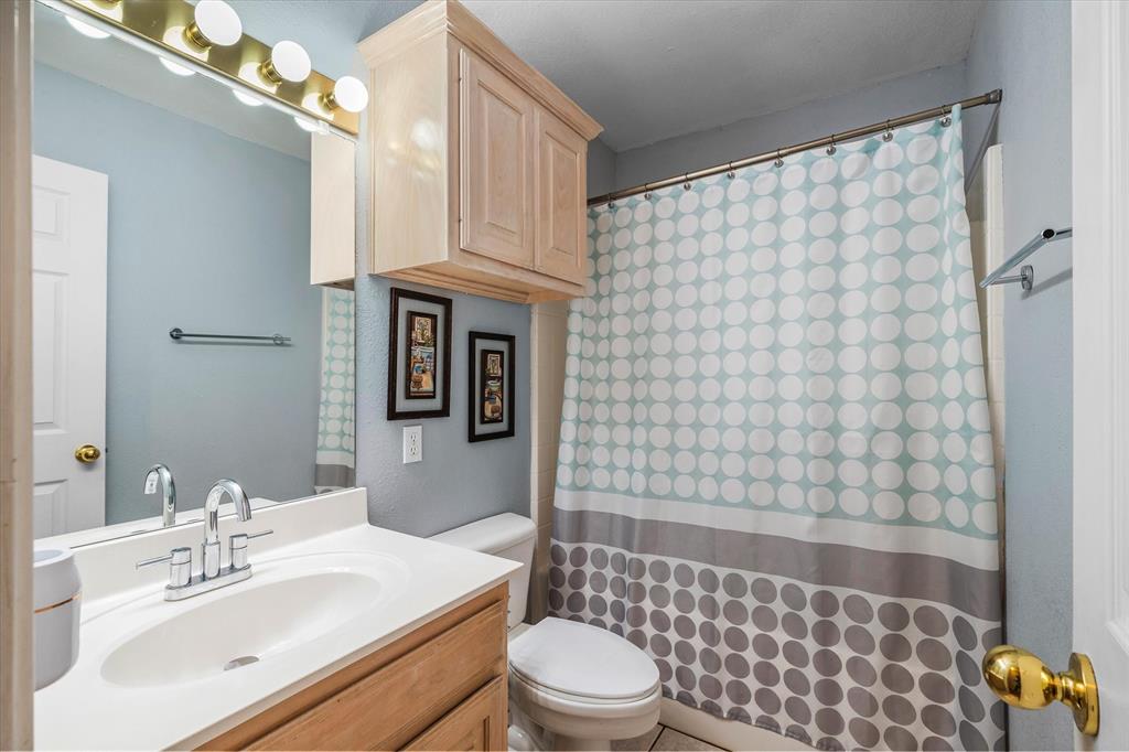 560 Washington Street Van, TX 75790 - Photo 9 of 29 a bathroom with a sink a toilet and shower curtain