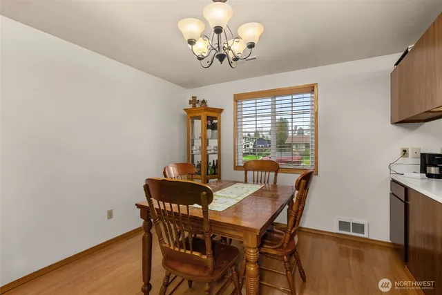 view of a hallway with wooden floor and a bathroom