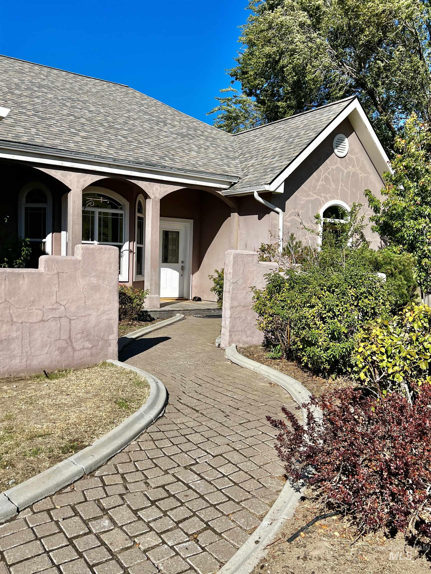 Stucco exterior with arched entryways, arched windows, and a shingle roof