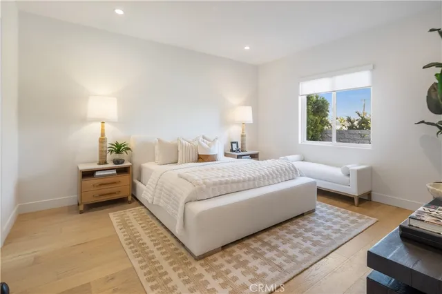 a bedroom with a large bed and a potted plant