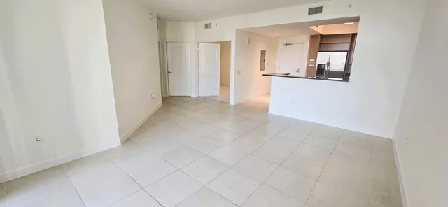 a view of a hallway with wooden floor and a living room