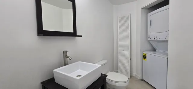 a bathroom with a toilet sink and mirror