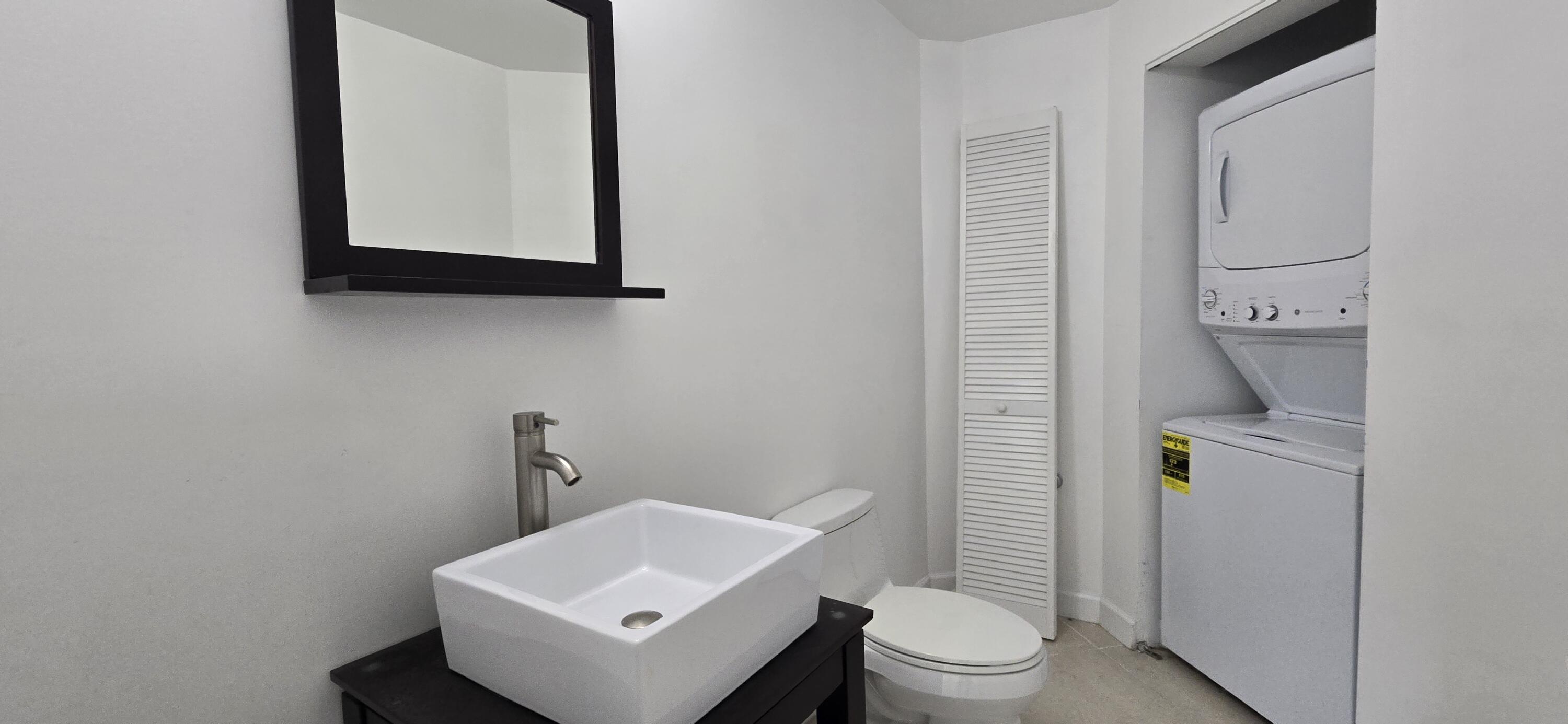 410 Evernia Street, Unit 616 West Palm Beach, FL 33401 - Photo 10 of 23 a bathroom with a toilet sink and mirror