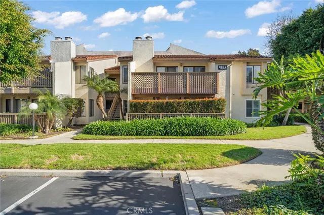 a front view of a house with a yard and potted plants