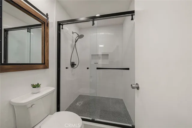 a bathroom with a shower a toilet and sink