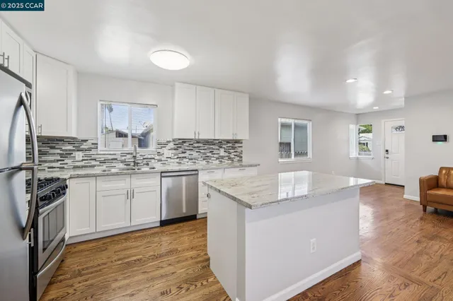 a kitchen with granite countertop a sink stove and cabinets