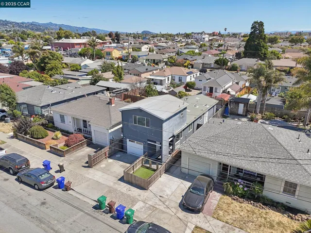 an aerial view of residential houses with outdoor space and parking
