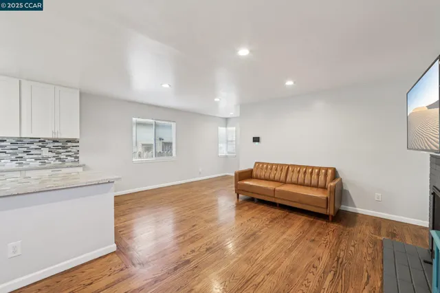 a spacious bedroom with a bed and a wooden floor