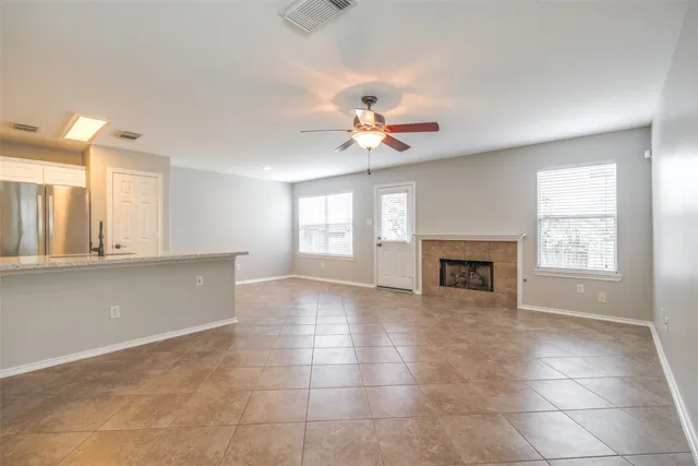 a view of an empty room with a fireplace and a window