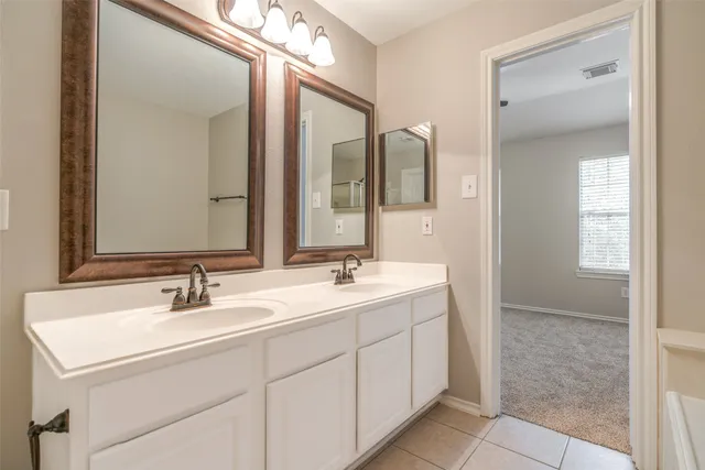 a bathroom with 2 sink and a mirror